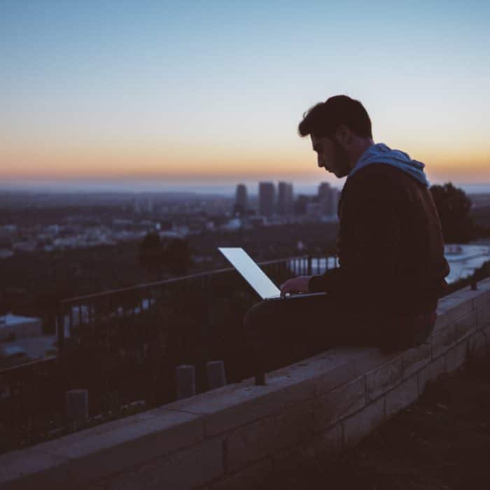 man working on laptop overviewing the ciy