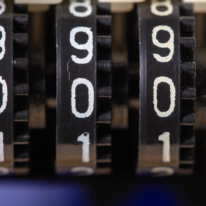 Old three-position mechanical counter with zero digits, low shallow focus