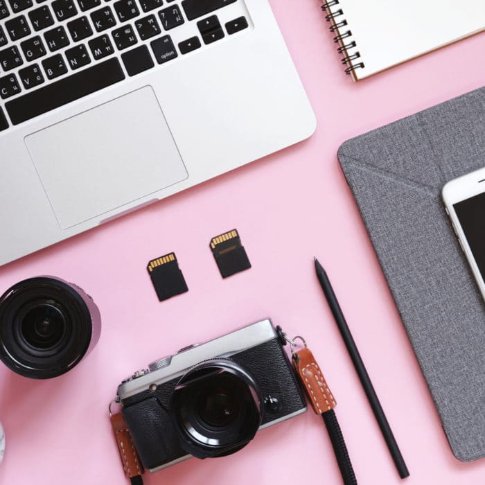 Desktop flat lay photo of workspace desk with laptop, camera, ta