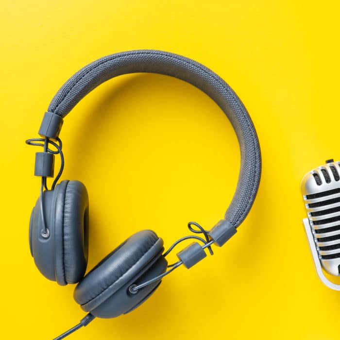 headphones and retro microphone on yellow background