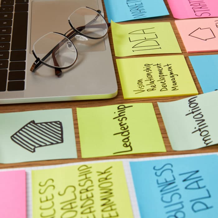 paper stickers with business strategy and laptop with glasses on