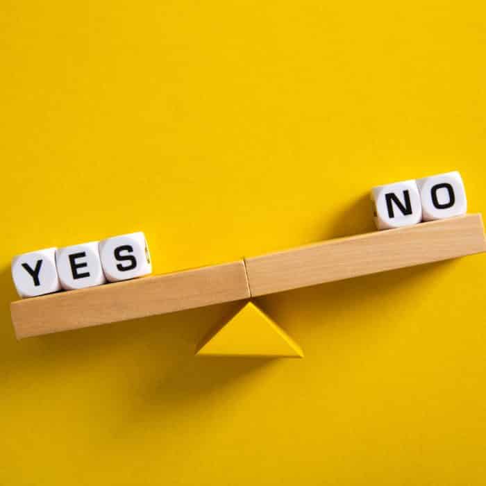 Yes vs No. Choice concept. Balance scales on yellow background.